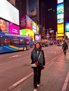 Persona en Times Square de noche en Nueva York con luces y pantallas iluminadas