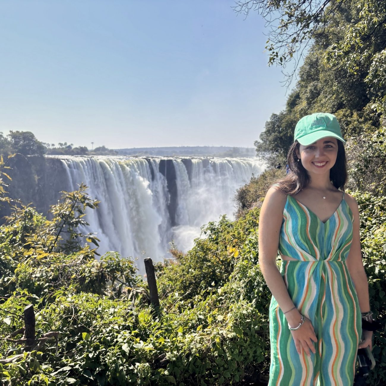 Persona posando frente a las Cataratas Victoria desde el lado de Zimbabue, una de las cascadas más impresionantes de África.